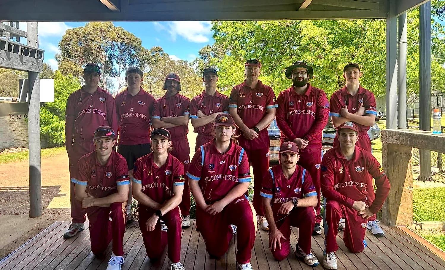 Newcomb & District men's team under a timber pavilion, back row standing and front row kneeling
